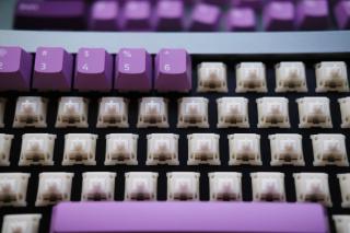 A close-up shot of keycaps being installed on a keyboard.