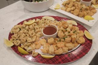 A platter full of fried battered shrimp and calamari.