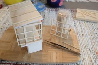 A partially constructed model of a ramen stand, drying after being glued.
