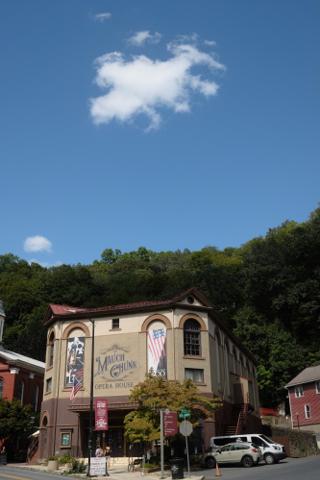 A puffy cloud in a clear blue sky hovers over the Mauch Chunk Opera House.