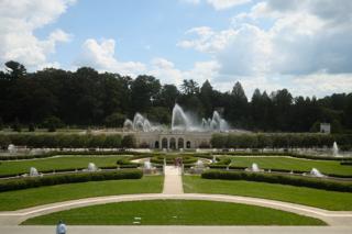 Fountains blown by the wind in an expansive outdoor plaza at Longwood Gardens in Pennsylvania.