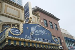 A salt-water taffy shop marquee missing multiple letters.