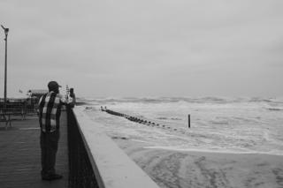 A man photographs the waves kicked up by hurricane Erin.