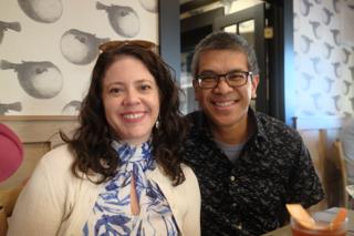 A couple smile inside a restaurant.