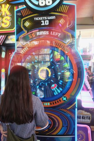 A young woman plays an arcade game.