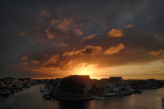 Sunset along the canals of Manahawkin, NJ. The clouds are lit up from the setting sun in hues of purple, yellow, and orange.