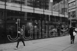 "Juilliard" stenciled in large, outlined sans-serif on the side of a glass wall.