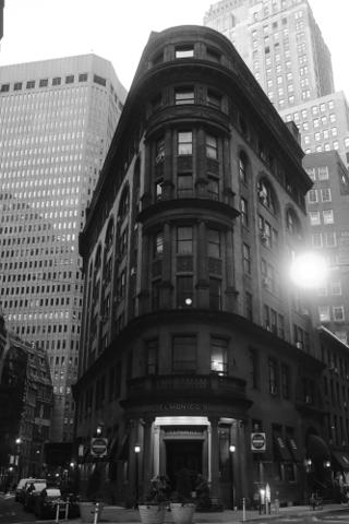 A building at a triangular intersection, in the dim dawn light.