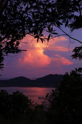 Sunset reflecting on a bay with a small boat in the foreground