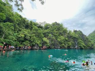 Swimmers in turquoise water of a secluded lake