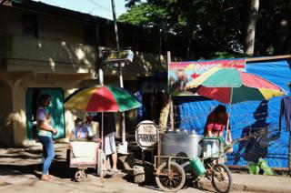 Street vendors for ice cream with multicolored umbrellas for shade.