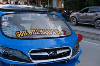 A tricycle emblazoned with the slogan “God Will Make a Way 2” on the windshield.