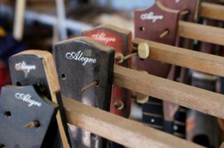 A closeup of assembled guitars hanging in a row.