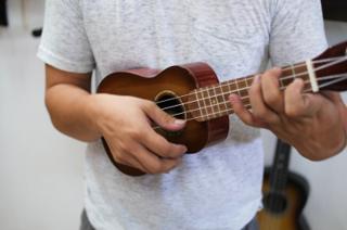 A closeup of a man holding a ukelele.