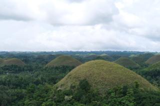 A series of small brown hills recedes into the horizon.