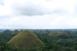 A series of small brown hills recedes into the horizon.