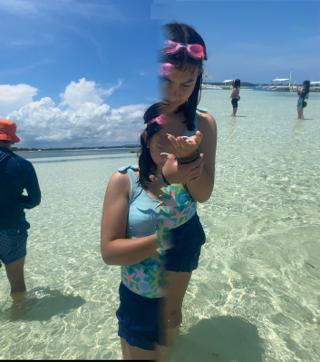 A photo glitch splitting the frame in half vertically, so that a girl in the foreground looks like the two halves of her body are offset.