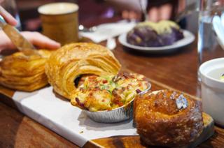 A board with a row of flaky pastries and mini-quiche.