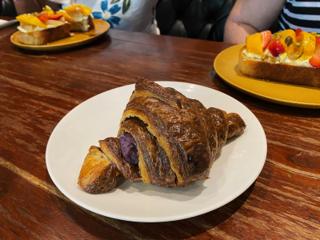 A croissant with ube jam peeking through the layers.