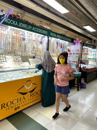 Looking down on the market stalls Looking down on a vast hall filled with market stalls. The ceiling above them is strung with different hanging advertisements.