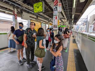 A family waits on a JR rail platform.