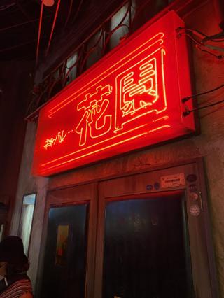 Red neon sign saying “Flower Garden”.