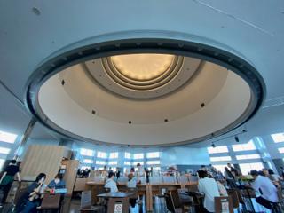 Tourists shopping and sitting underneath a domed ceiling.