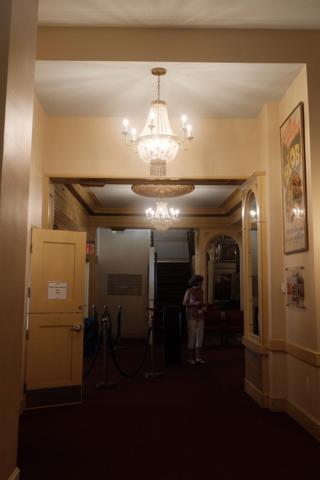 A hallway lit by small chandeliers.
