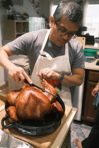 A man carves a Thanksgiving turkey