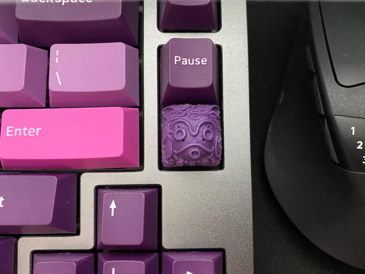 Press the lil’ guy to mute A purple artisan keycap.