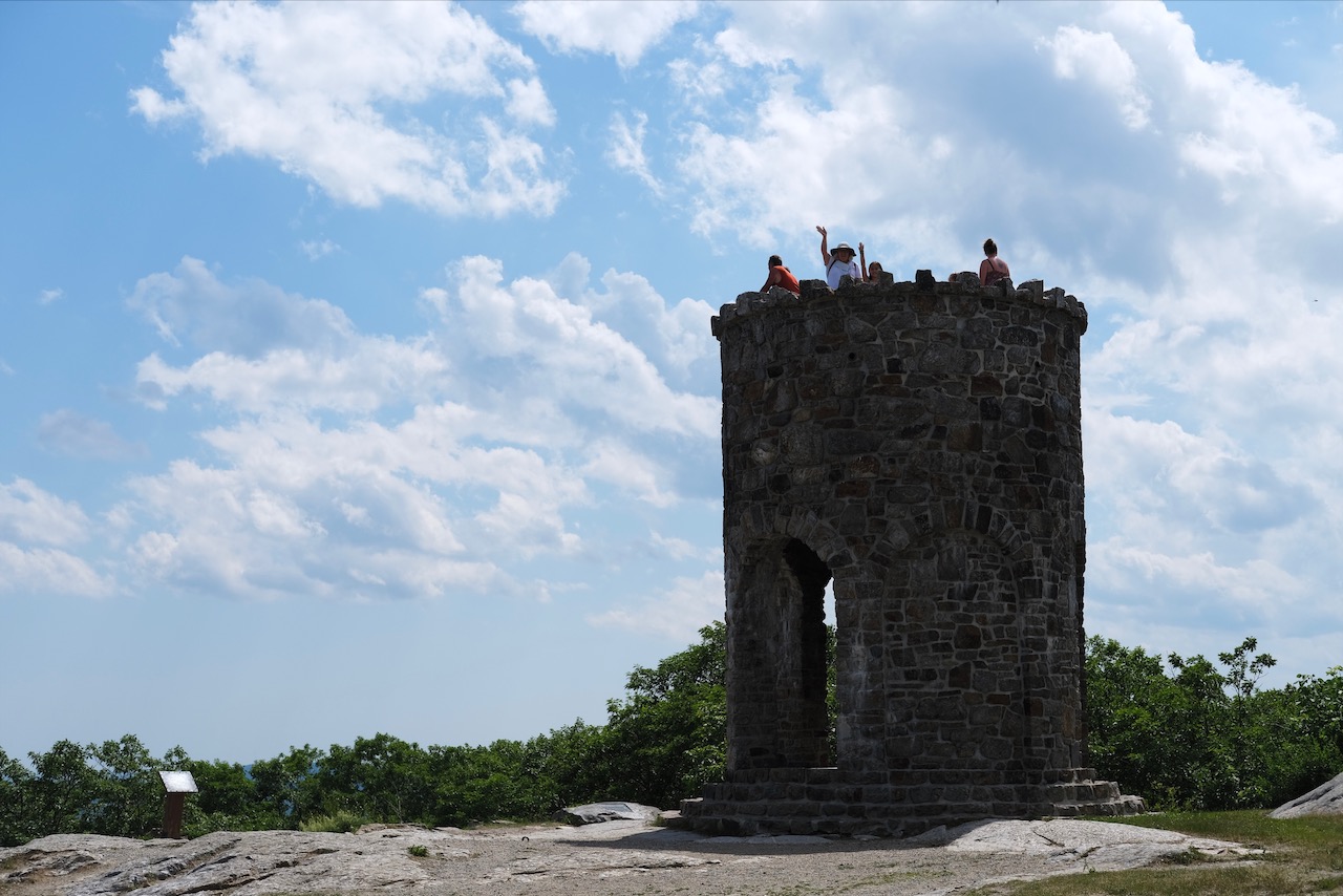 Sophie and Debbie waving from atop the Memorial Tower Woman and a girl waving from atop a stone tower.