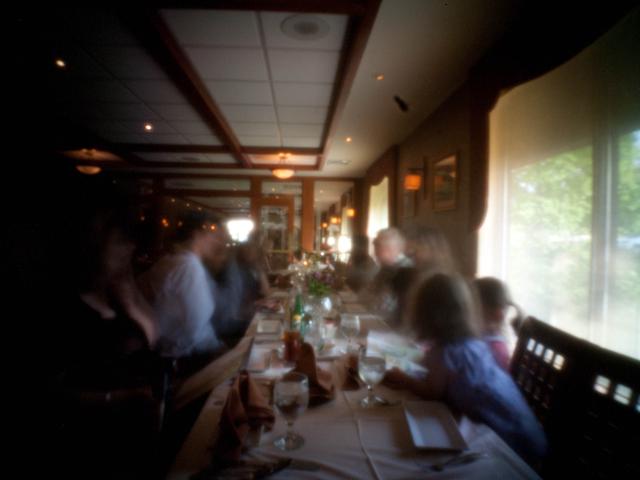 Long-exposure pinhole photo of a dinner table in a restaurant.