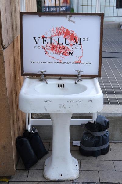 Repurposed sink holds up a Vellum Soap Company sign