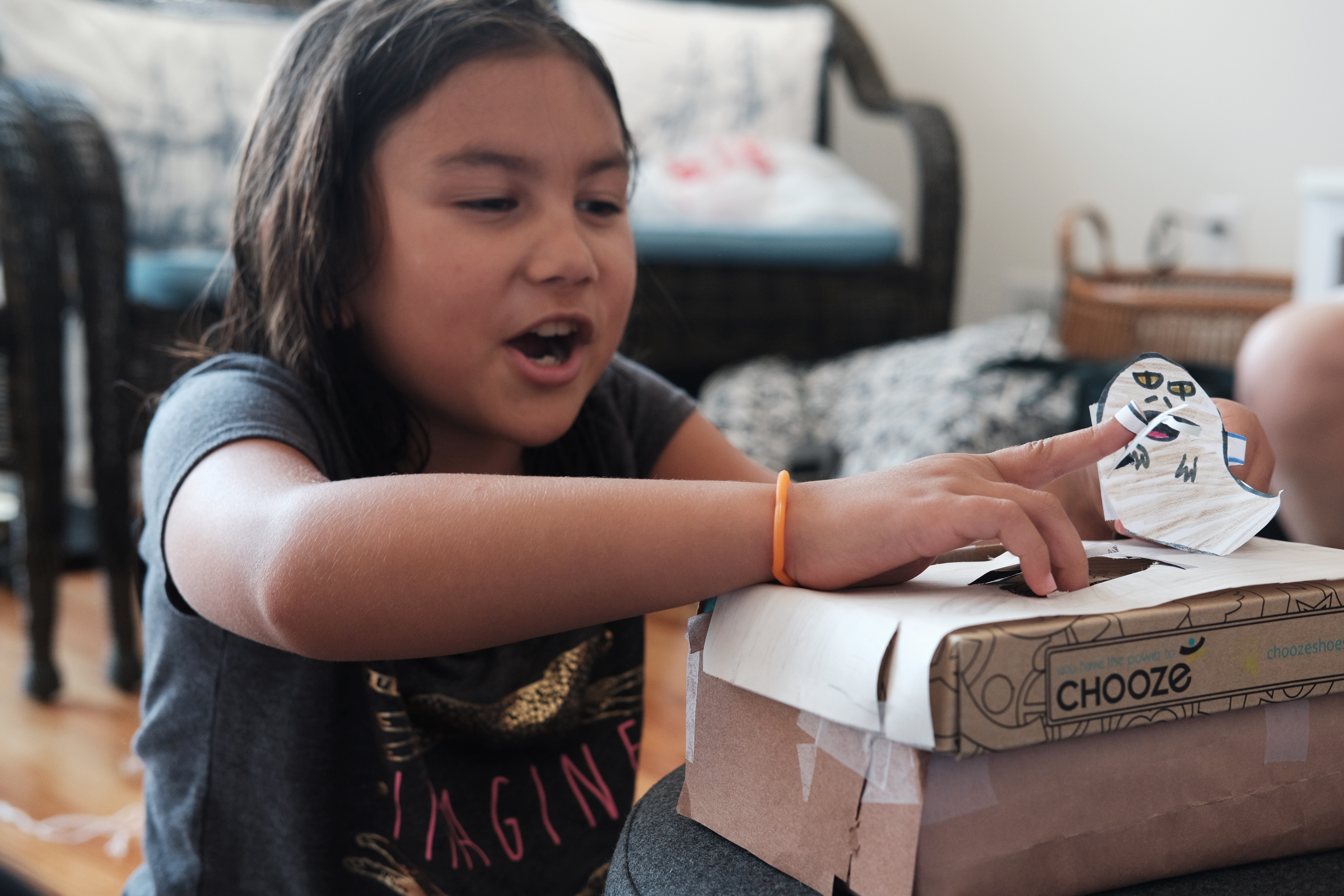 Jabba laughs as Luke falls through a trap door. A young girl acts out a scene from Return of the Jedi using paper puppets.