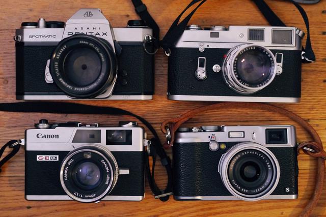 Four silver-and-black cameras shot from above.