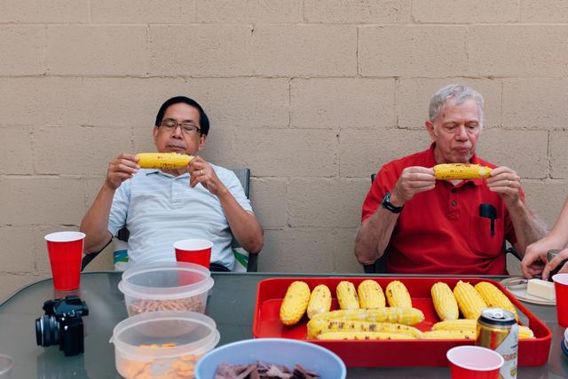 Two men eating corn on the cob