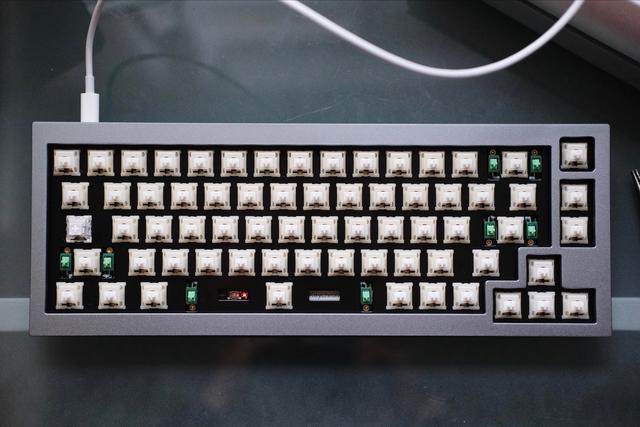 A top-down shot of a grey 65% keyboard white keyswitches.