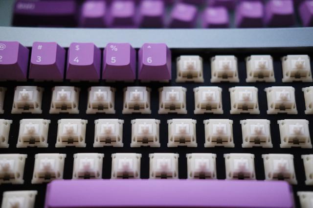 A close-up shot of keycaps being installed on a keyboard.