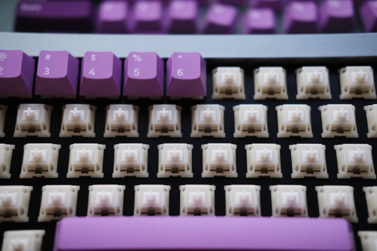 A close-up shot of keycaps being installed on a keyboard.