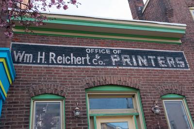 Sign on side of brick building: Office of Wm. H. Reichert & Co. PRINTERS