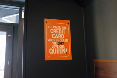Sign saying “If cash is king credit card must be queen. We only love our queen!”