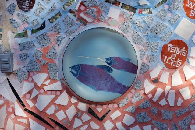 Two painted fish embedded in tile.