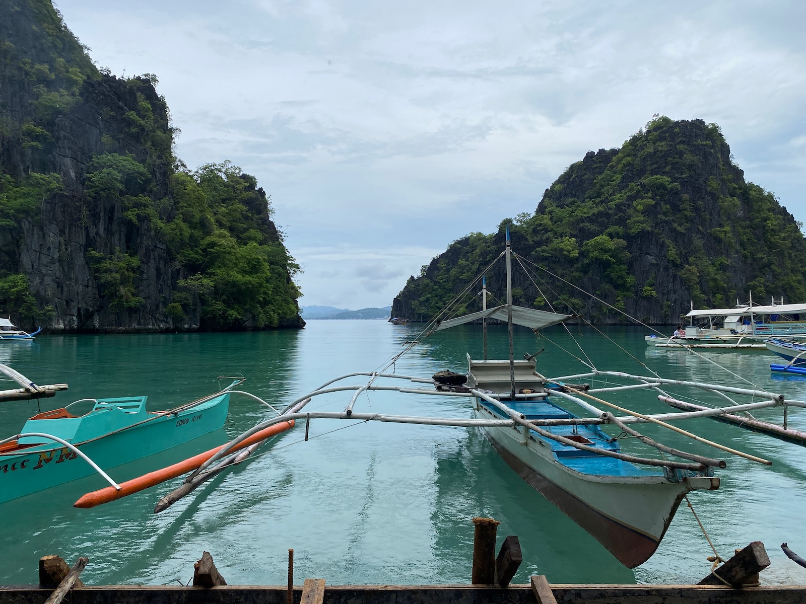 Outrigger boats tethered to a wooden walkway