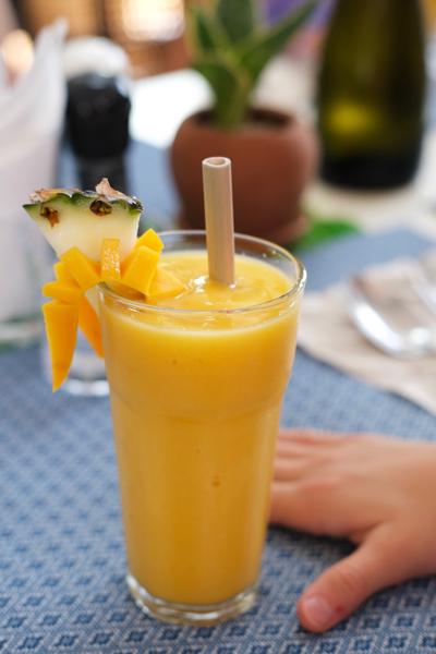 Close-up view of a mango shake in a tall glass.