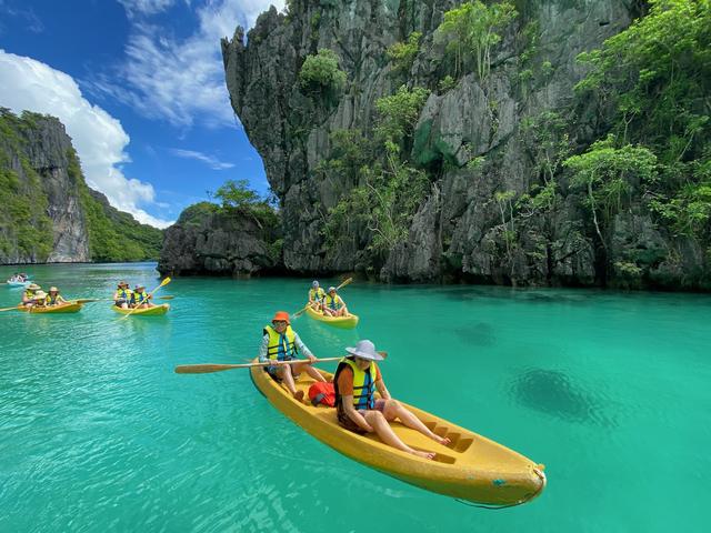 Four kayaks in a lagoon with clear teal water.