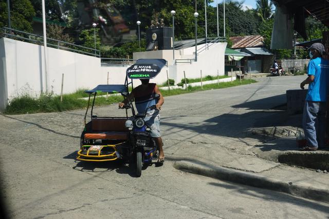 A small tricycle powered by an e-bike. “Always Somewhere” emblazoned on a sunshade above the driver.