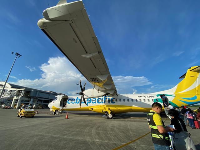 A small propeller plane with passengers boarding.