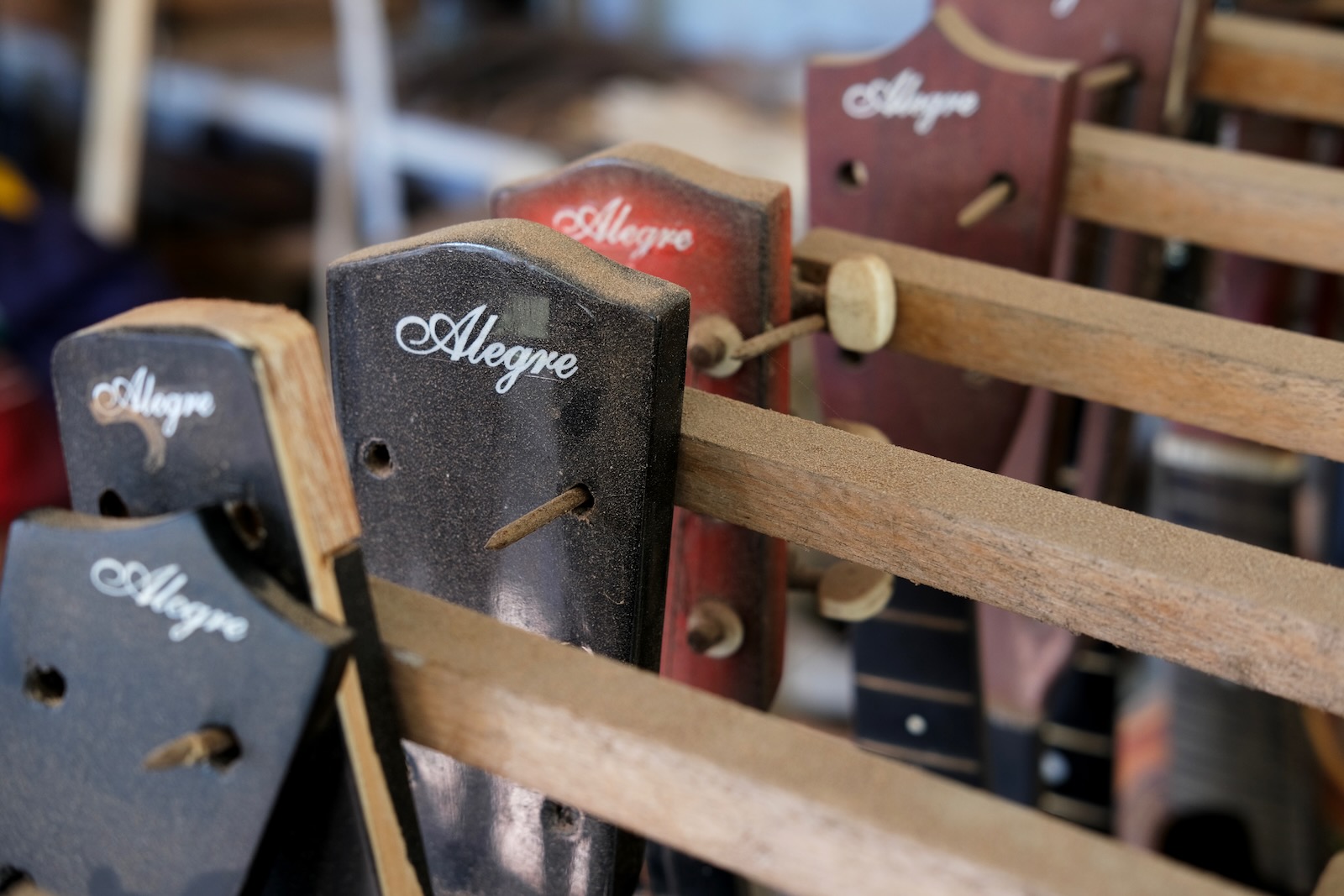 A closeup of assembled guitars hanging in a row.