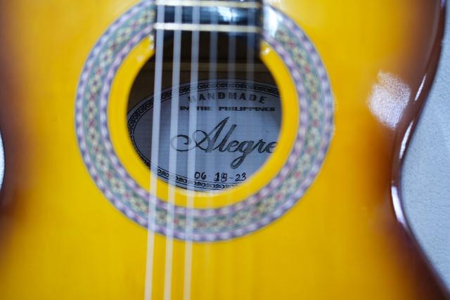 A shot of the interior of a guitar, reading “Handmade in the Philippines”.
