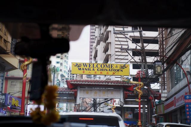 A decorative arch with golden dragons reading “Welcome to Manila Chinatown”.